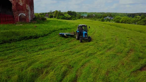 Tractor Mows the Grass at the Ancient Church