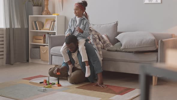 Dad and Two Little Girls Having Fun Playing Dice at Home alt