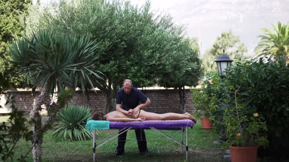Masseur Massages a Girl with a Beautiful Body alt