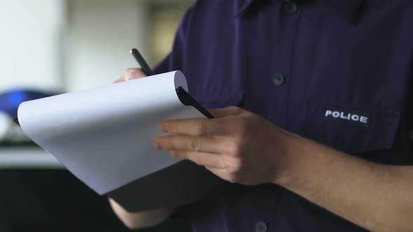Patrolman Completing Crime Scene On-Site Report Standing Near Squad Car Accident alt