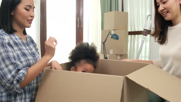 Happy asian women LGBT lesbian couple holding boxes entering new modern house alt