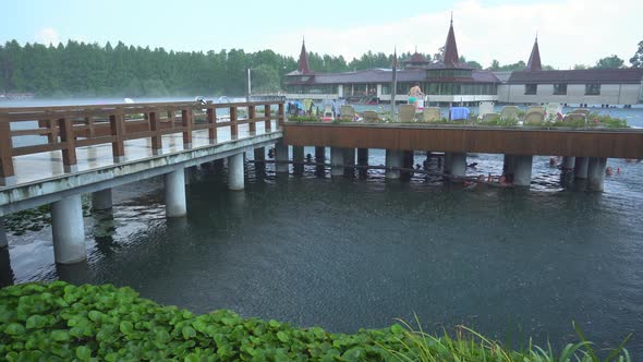 Spa Complex Buildings and Small Water Lilies on Thermal Heviz Lake in the Rain Hungary   Handheld alt