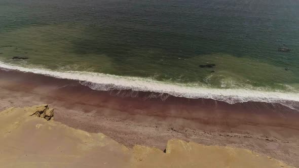 Drone Footage of Green Waves White Tide Multicolored Shoreline Clay Beach