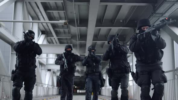 SWAT Police Officers Covering Each Other with Assault Rifles During Operation alt