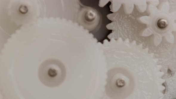 Five Plastic Gears Rotate in Mutual Mesh Inside a Small Reduction Gear