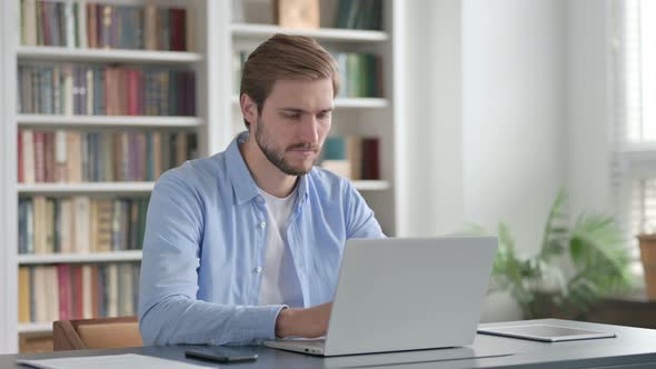 Man Shaking Head As No Sign While Using Laptop alt