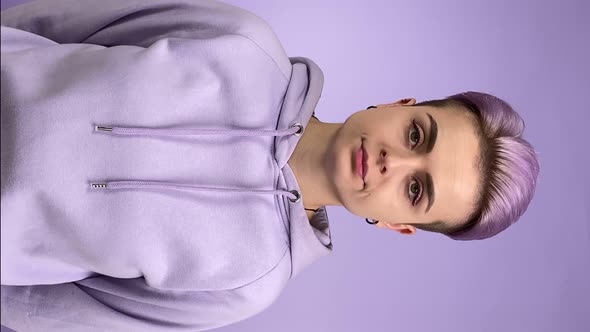 Vertical Shot Young Woman Turning Head Left Right on Purple Background alt