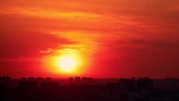 Morning sky at dawn with a large sun rising over the city, sunrise, timelapse