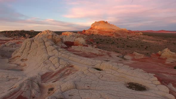 Panning view of desert landscapes as sun lights up in the background alt