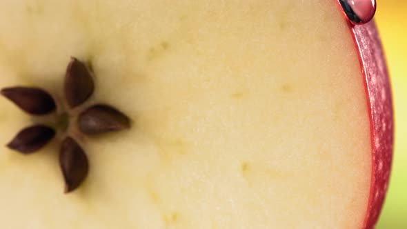 Drop of Water Flows Down the Surface of a Ripe Juicy Red Apple Slice alt
