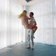 Blonde Woman Jumps into Arms of Man and He Spins Around near French Window - VideoHive Item for Sale