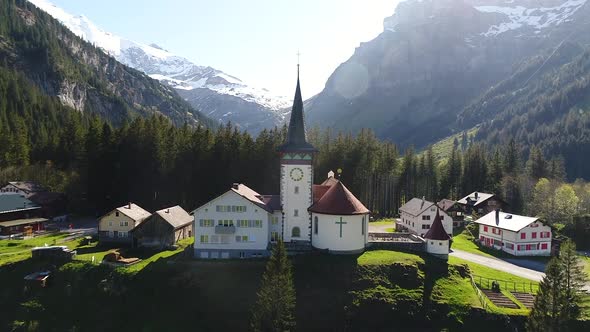 Aerial video of a church in a villiage along the Klausen Pass in Switzerland. alt