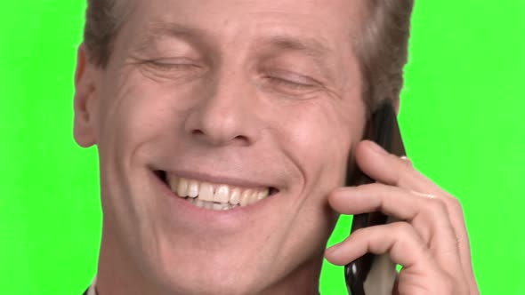 Mature Face Pleasantly Talking on Mobile Phone. alt