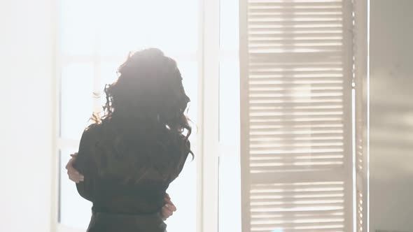 Backside View Slim Girl Approaches Windows with Shutters alt