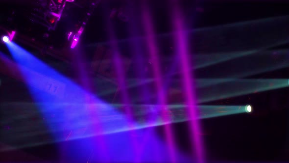 Multiple colorful turned on stage lights mounted to ceiling flashing in the dark room. Concert hall alt