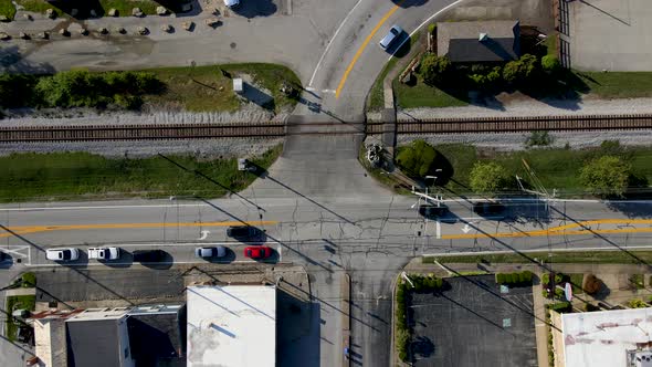 Aerial/Drone footage of Intersection with Cars, Railroad Tracks, Vertical Rise