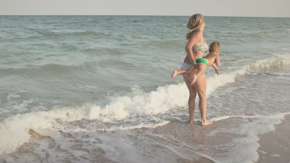 Mom Throws Her Son Up Over the Sea on Summer Vacation Under the Warm Sun alt