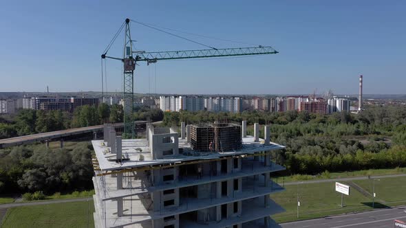 Workers work with crane and steel concrete reinforcement at large construction site alt