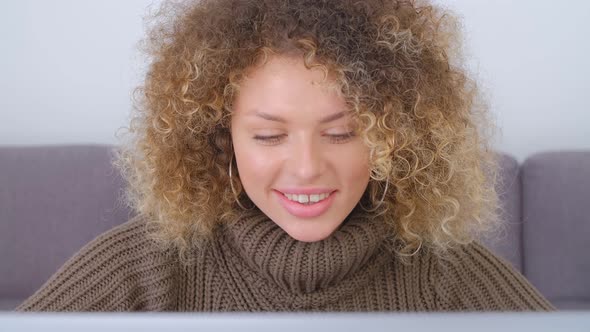 Beautiful young adult woman doing freelance work online with notebook computer in 4k video alt