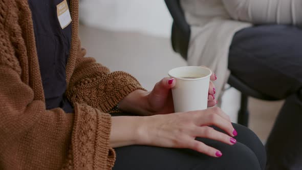 Close Up of Nervous Woman Holding Cup of Coffee and Trembling at Aa Therapy Meeting alt