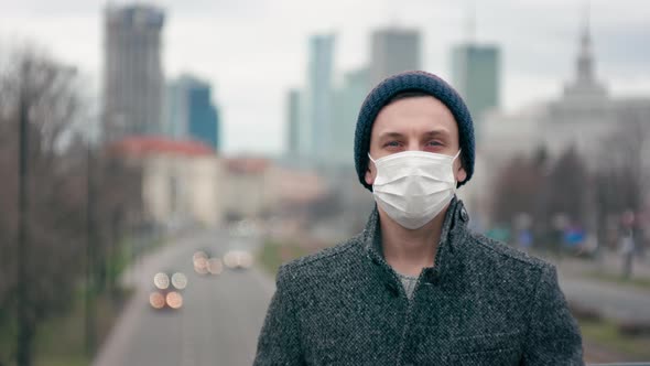 COVID-19 Coronavirus Pandemic: Portrait of Man in Surgical Face Mask in Big City