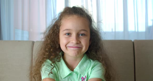 Portrait Honey Little Girl Smiling Child Looking at Camera are Sitting on the Couch at Home Cute Kid alt