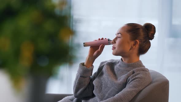 Girl Uses Face Pore Vacuum Cleaner in Office alt