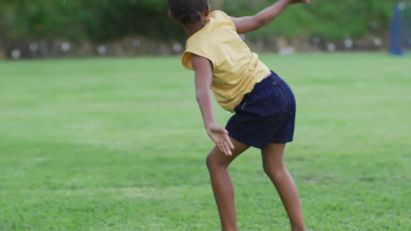 African american schoolgirl doing cartwheels during physical education class outdoors alt