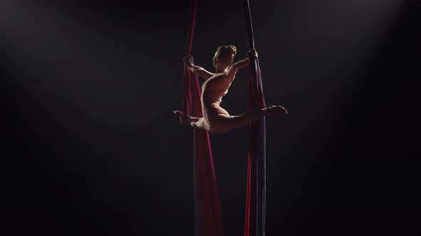 Young Female Circus Gymnast Spins on Aerial Silk and Demonstrates Stretching alt