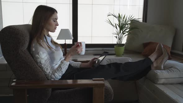 Smiling Woman Watching Funny Photo On The Tablet alt