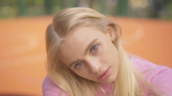 Close-up of Young Blond Woman with Grey Eyes Looking at Camera and Smiling. Portrait of Charming alt