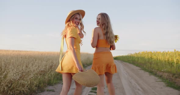 Two Cute Blondes are Walking in the Field alt