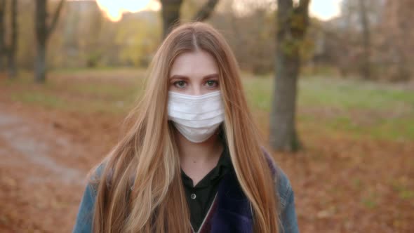 Portrait of a Young Attractive Woman in a Medical Protective Mask with Long Hair