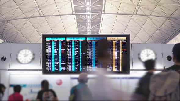 Tourists at International Airport Terminal Flight Timetable. Travel Concept Time lapse alt