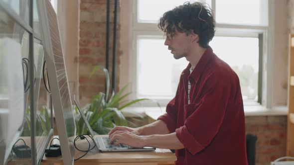 Businessman Charging Laptop with Solar Panel at Work in Office alt