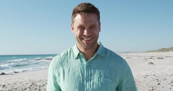 Man standing on the beach and looking at camera alt