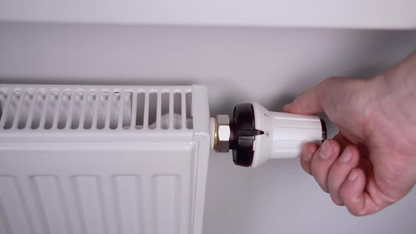 The Male Hand Controls the Heating of the Battery with a Controller alt