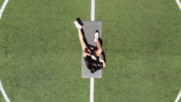 Aero, Top View, Fitness Woman in Sportswear Doing Various Exercises on Sports Mat, on Green Football alt