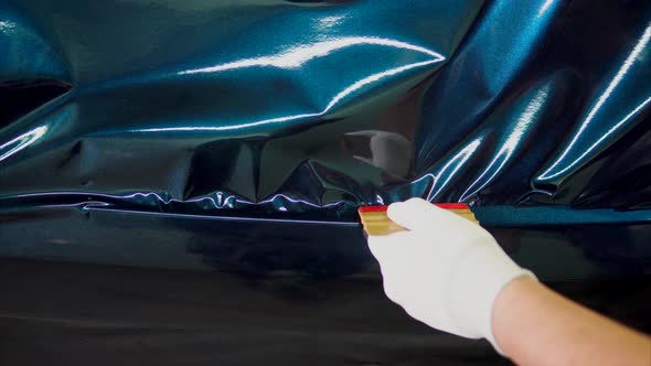 Close Up Shot of Man's Hands Removes Air Bubbles While Tuning Car alt