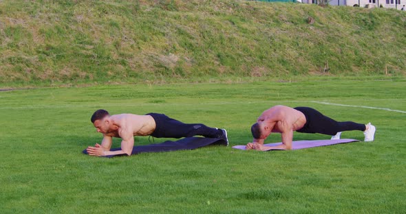 Shirtless Men Doing Plank Exercise Outdoors alt