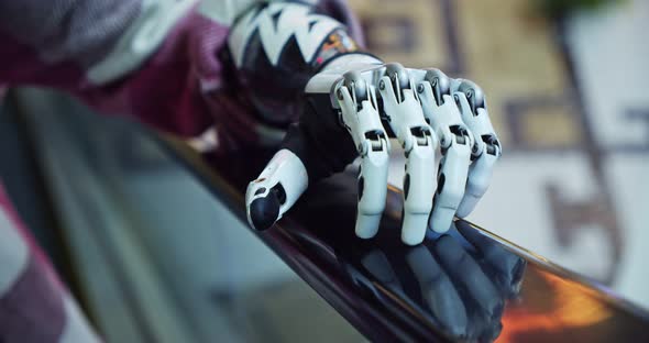 Closeup of a Bionic Hand Holding on to the Handrail on the Escalator alt