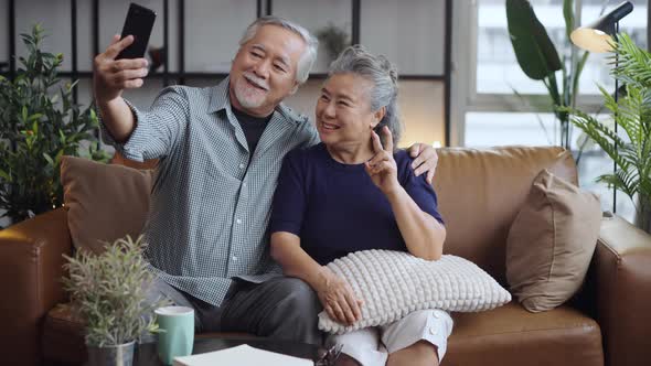 Portrait happy Asian mature senior couple selfie at the phone camera and smiling.