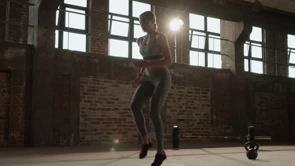 Workout. Woman doing high knees running in place exercise at gym alt