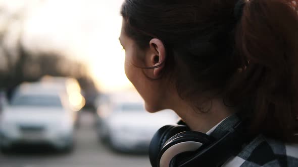 Side View of a Girl with Headphones Around Her Neck alt