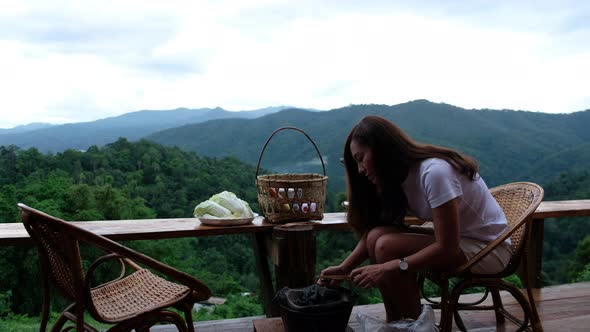 An asian woman preparing and lighting fire in a stove before cooking Moo Kata