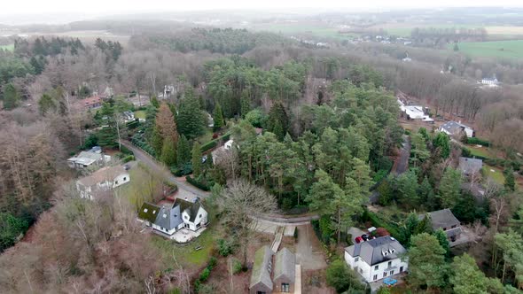 Aerial View of Big Villas with Garden Surrounded By Forest During Winter Season alt