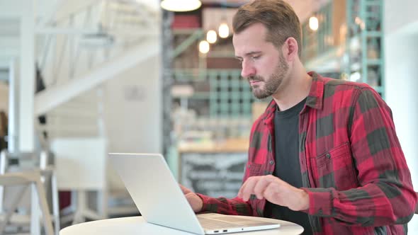 Young Man with Laptop Standing and Going Away alt