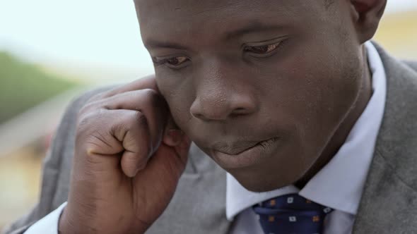 pensive day dreaming young african business man- close up alt