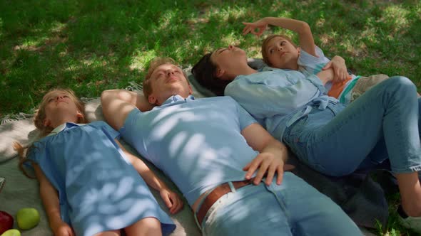 Happy Family Relax Lying on Picnic Blanket Close Up alt