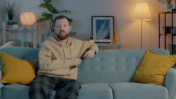 Portrait of Happy Couple in Pajamas Watching TV Hugging Smiling Looking ...